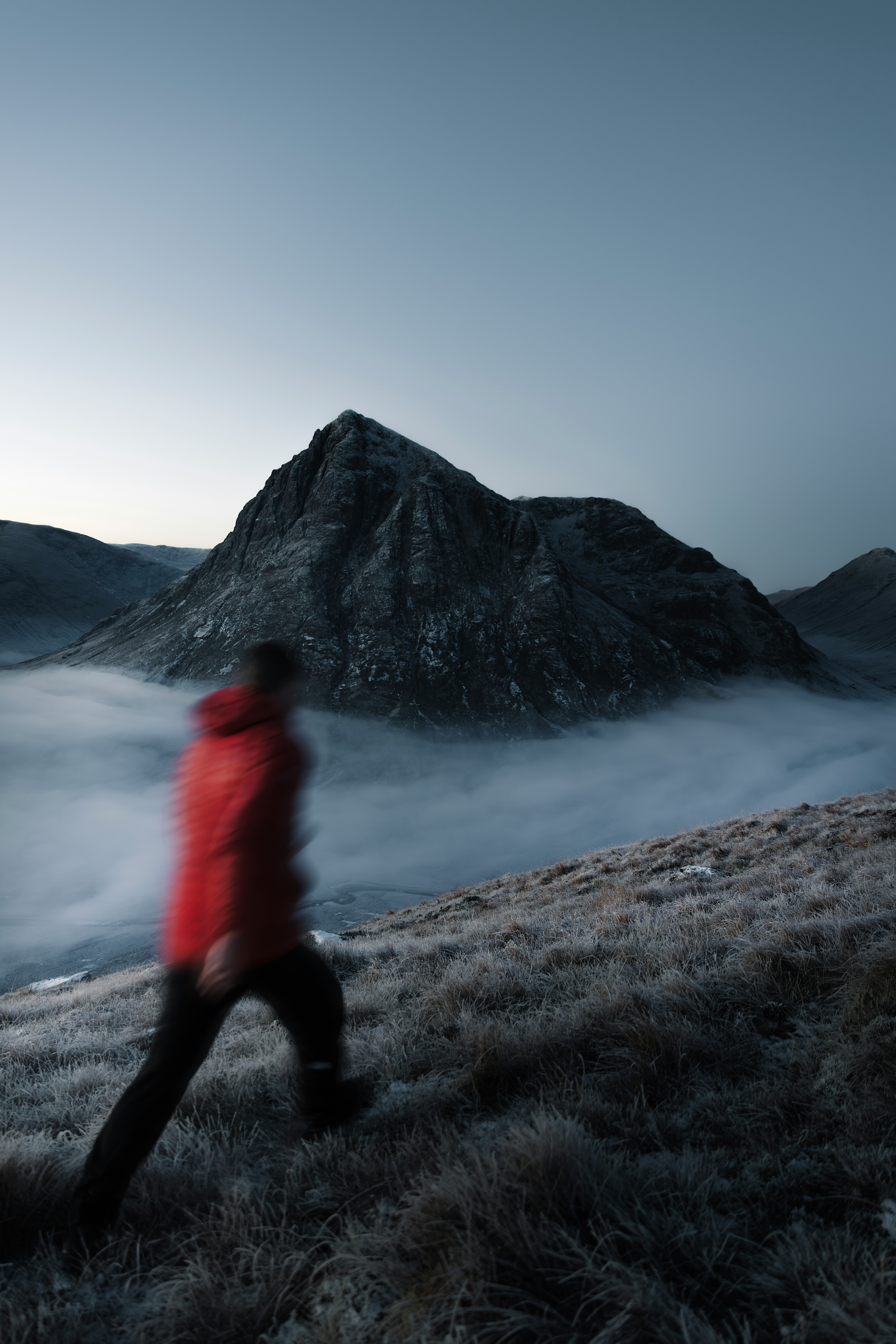 Man climbing steep terrain through mist